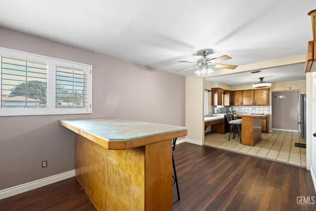a room with wooden floor table and a kitchen