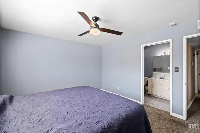 a bedroom with a bed and a ceiling fan