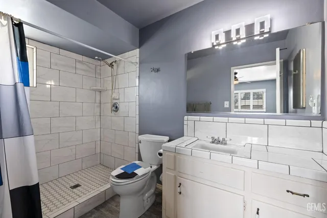 a bathroom with a sink a toilet and shower