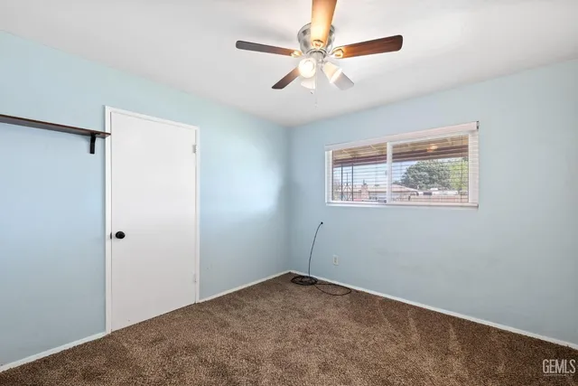 an empty room with wall painting and a ceiling fan