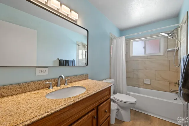 a bathroom with a granite countertop sink toilet and shower