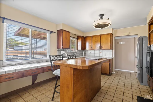 a kitchen with stainless steel appliances granite countertop a sink and a refrigerator