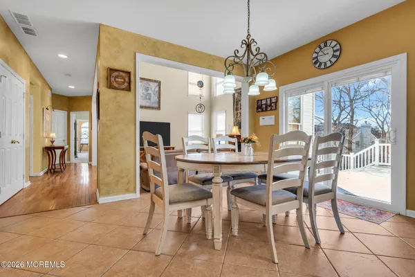 a dining room with furniture a chandelier and kitchen view