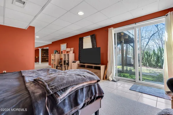 a spacious bedroom with a large bed and a flat tv screen