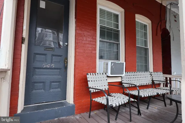 front view of a brick house with a chairs and table