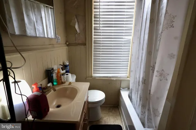 a bathroom with a sink and mirror with window