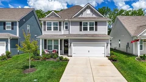 a front view of a house with a garden and plants