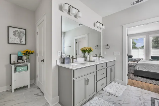 a en suite bathroom with a granite countertop sink and a mirror