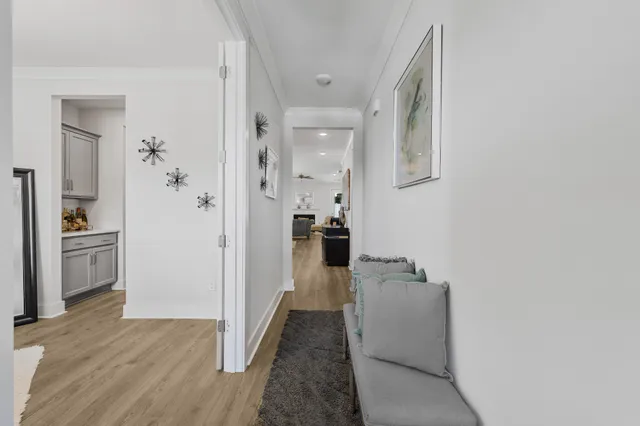 a view of a hallway with wooden floor and a living room