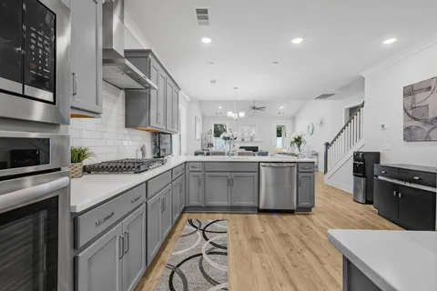 a kitchen with a sink a counter top space stainless steel appliances and cabinets
