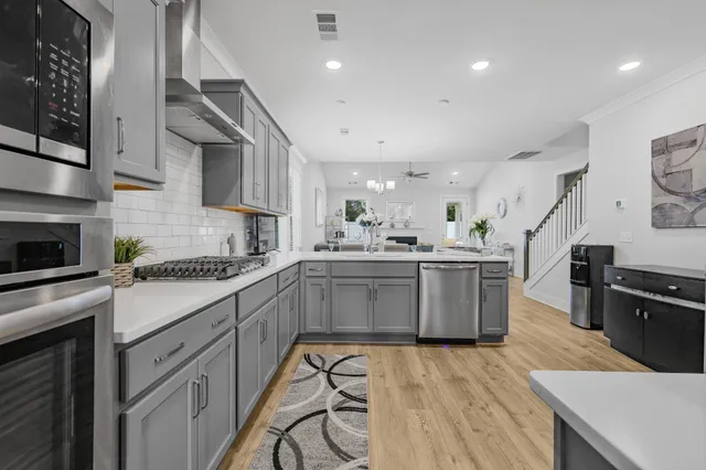 a kitchen with a sink a counter top space stainless steel appliances and cabinets