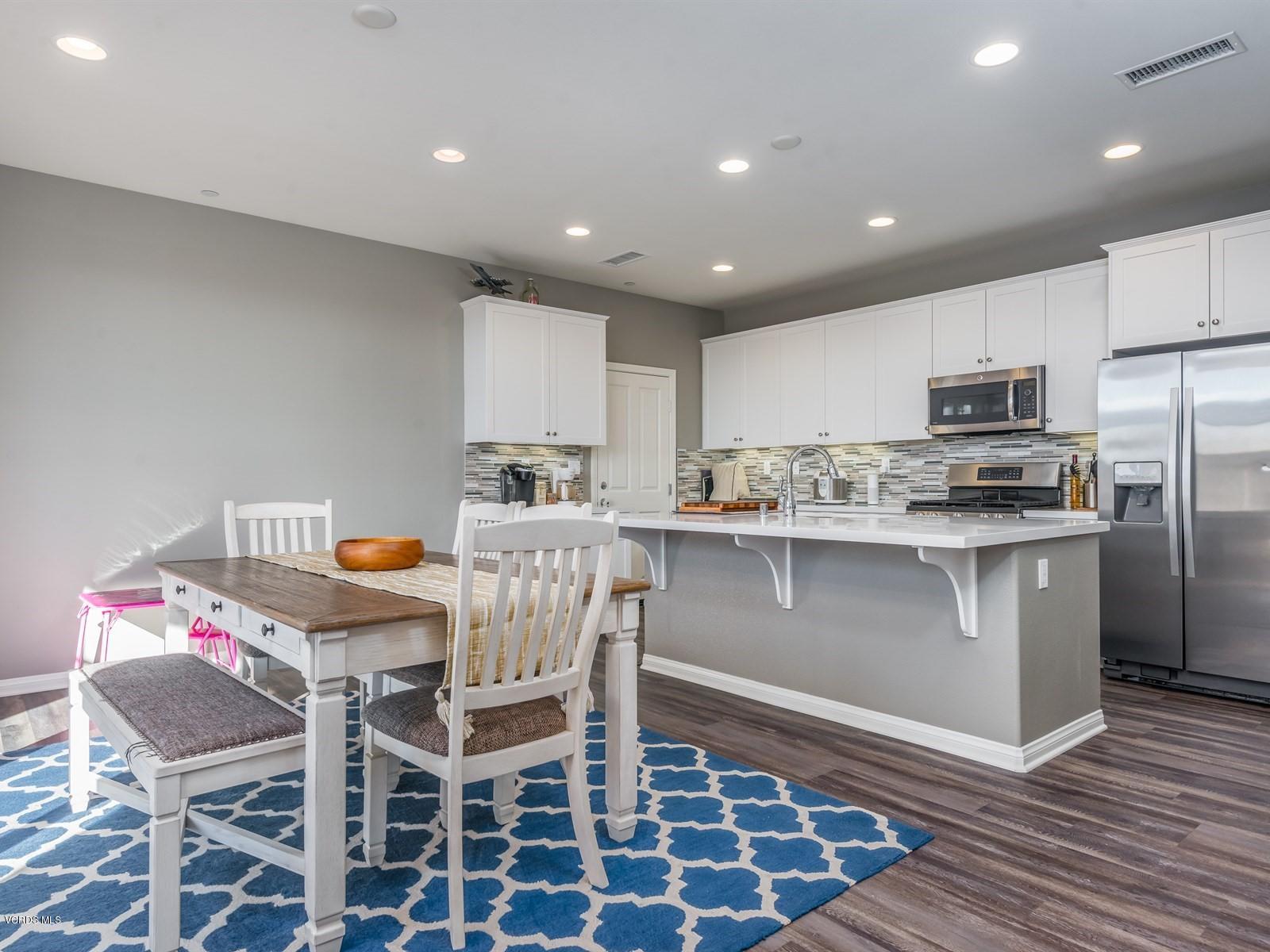 287 Stagetrail Road Camarillo, CA 93010 - Photo 11 of 30 a kitchen with stainless steel appliances granite countertop a stove a sink a refrigerator with a dining table and chairs