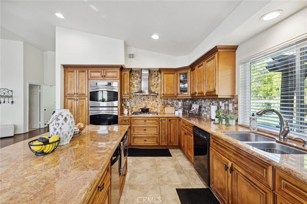 6752 Laurel Brook Drive Riverside, CA 92506 - Photo 19 of 53 a kitchen with stainless steel appliances granite countertop a stove a sink and a refrigerator
