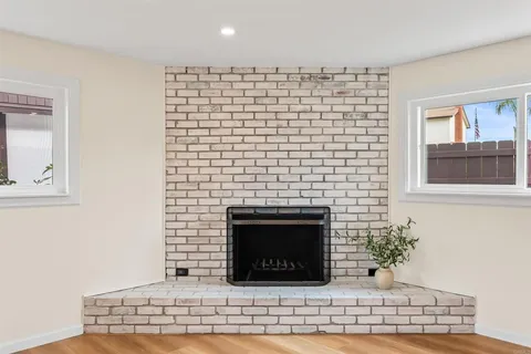 a view of empty room with wooden floor and fireplace