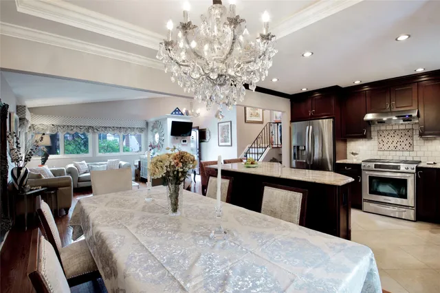 a kitchen with stainless steel appliances kitchen island granite countertop a table chairs in it and a window