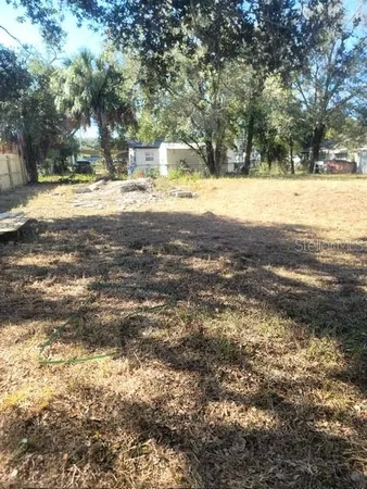 a view of yard with tree in the background