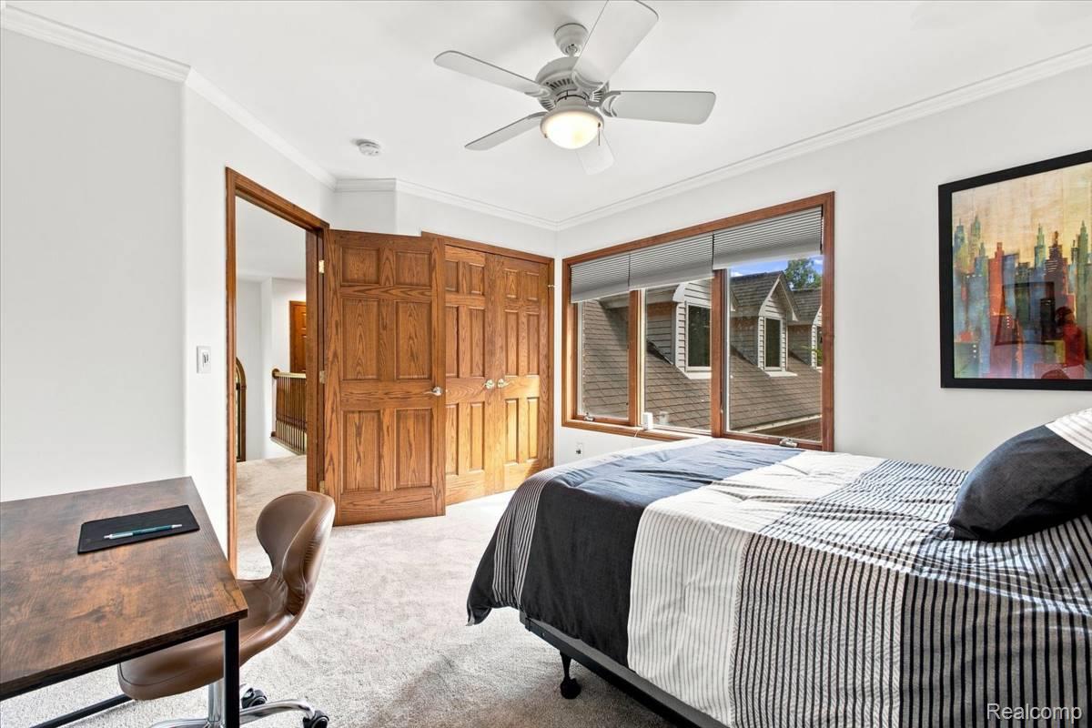 8610 Ferry Road Grosse Ile, MI 48138 - Photo 35 of 55 Hardwood panel doors, wood-trimmed window, ceiling fan, and light-toned carpet