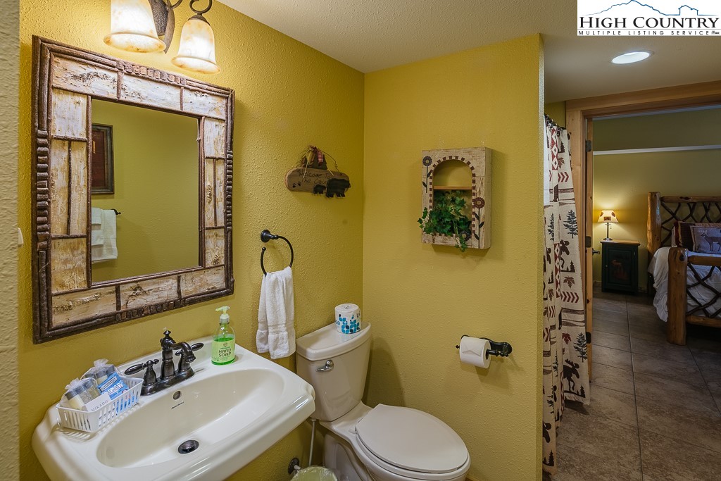 3320 Shawnee Road Banner Elk, NC 28604 - Photo 33 of 40 a bathroom with a sink and mirror with toilet