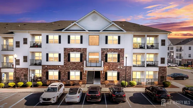 a front view of a building with cars parked