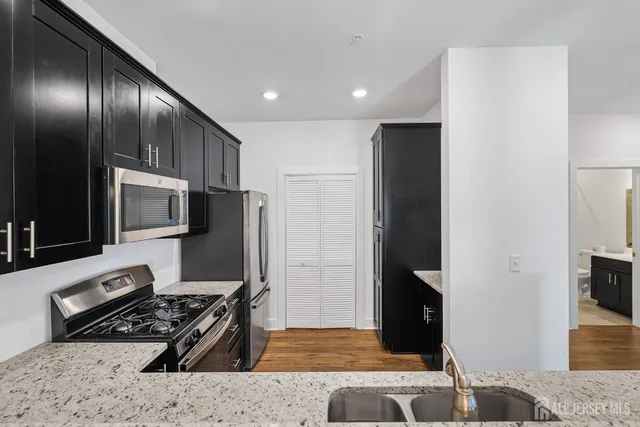 a kitchen with stainless steel appliances granite countertop a refrigerator and a stove
