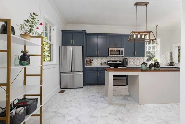 a kitchen with granite countertop a refrigerator and a stove top oven