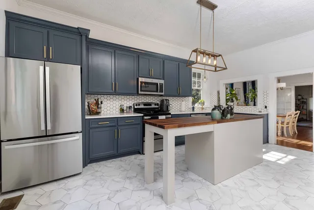 a kitchen with stainless steel appliances granite countertop a refrigerator a stove a sink and a microwave