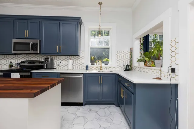 a kitchen with stainless steel appliances a sink a stove a microwave a sink and cabinets