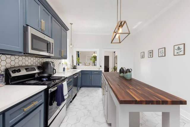 a kitchen with kitchen island granite countertop a stove and a sink
