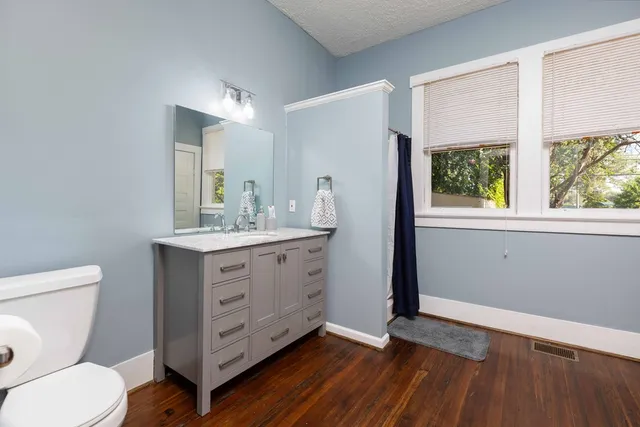 a bathroom with a toilet sink and mirror