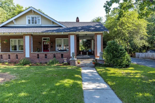 a view of a house with a yard patio and a small yard