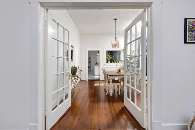 a view of a hallway with wooden floor and a living room