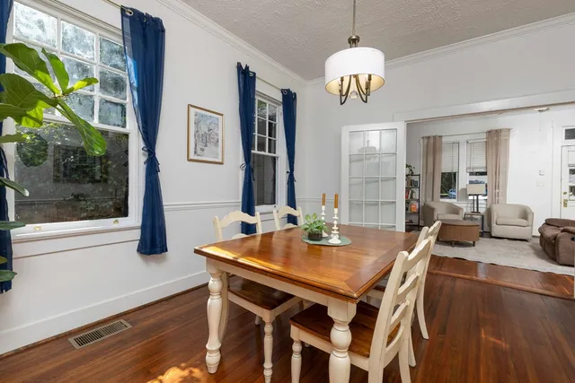 a view of a dining room with furniture a chandelier and wooden floor