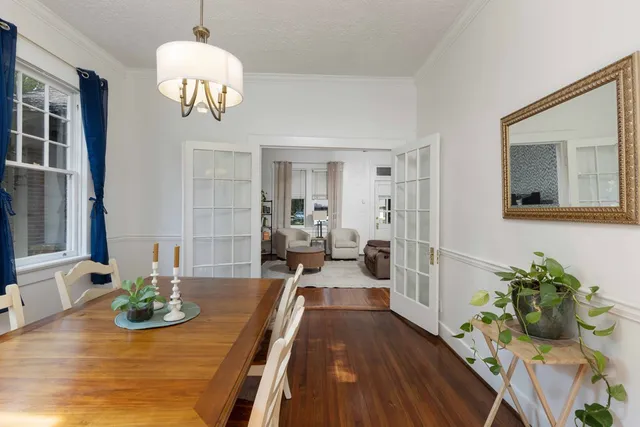 a view of a dining room with furniture a chandelier and wooden floor