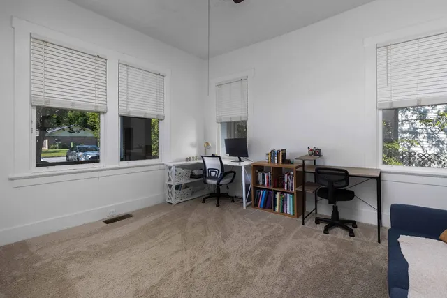 a view of a workspace with furniture and a window
