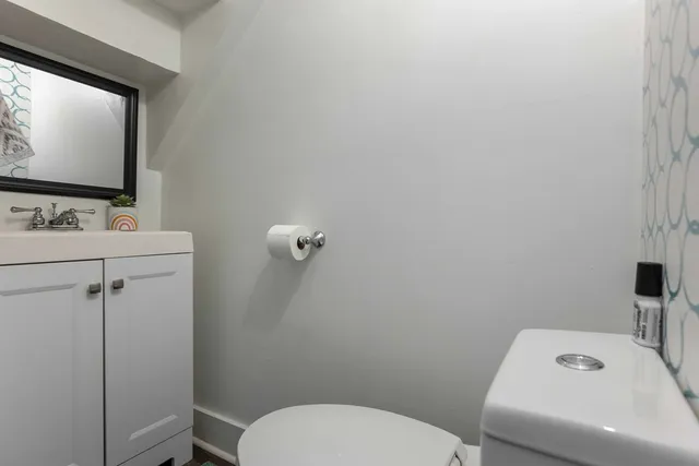 a bathroom with a toilet sink and mirror