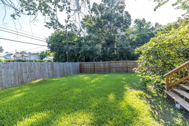 a view of yard with green space and wooden fence