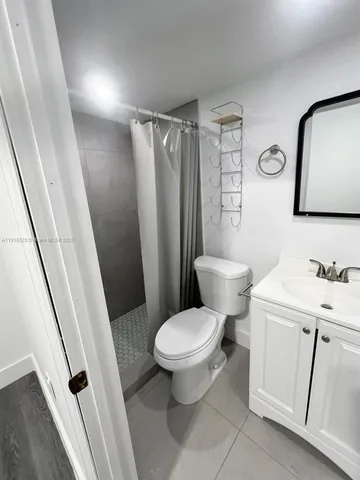 a white toilet sitting next to a bathroom sink and a mirror
