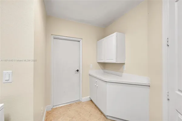 a view of a yard with plants and palm trees