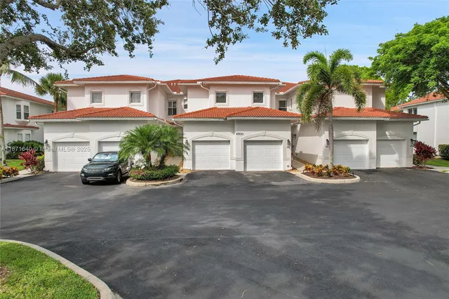an aerial view of a residential houses with outdoor space and lake view