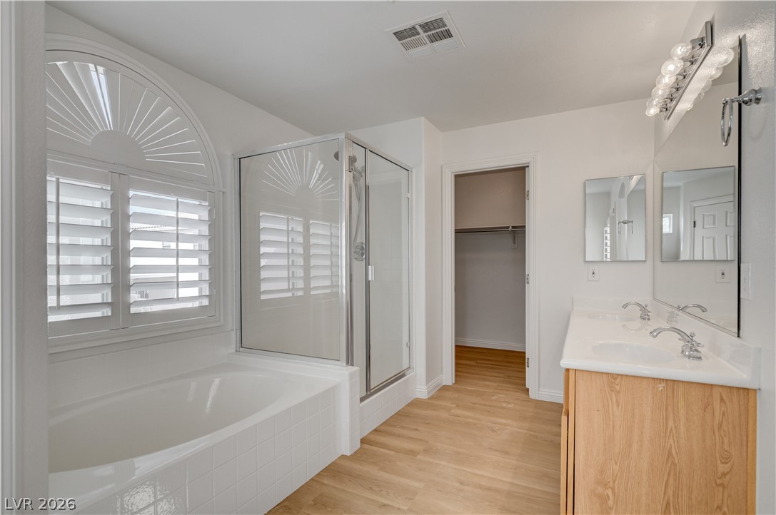 8918 Houston Ridge Avenue Las Vegas, NV 89178 - Photo 17 of 35 A well-appointed bath boasts dual vanities, a separate shower, and a built-in tub with window shutters.