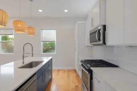 a kitchen with stainless steel appliances granite countertop a sink and a stove top oven