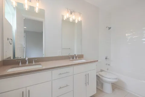 a bathroom with a granite countertop sink a toilet and a mirror