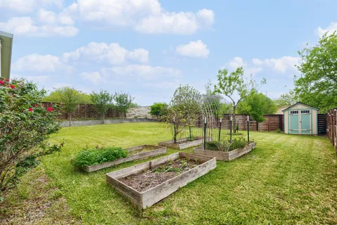 a view of a garden with a house in the background
