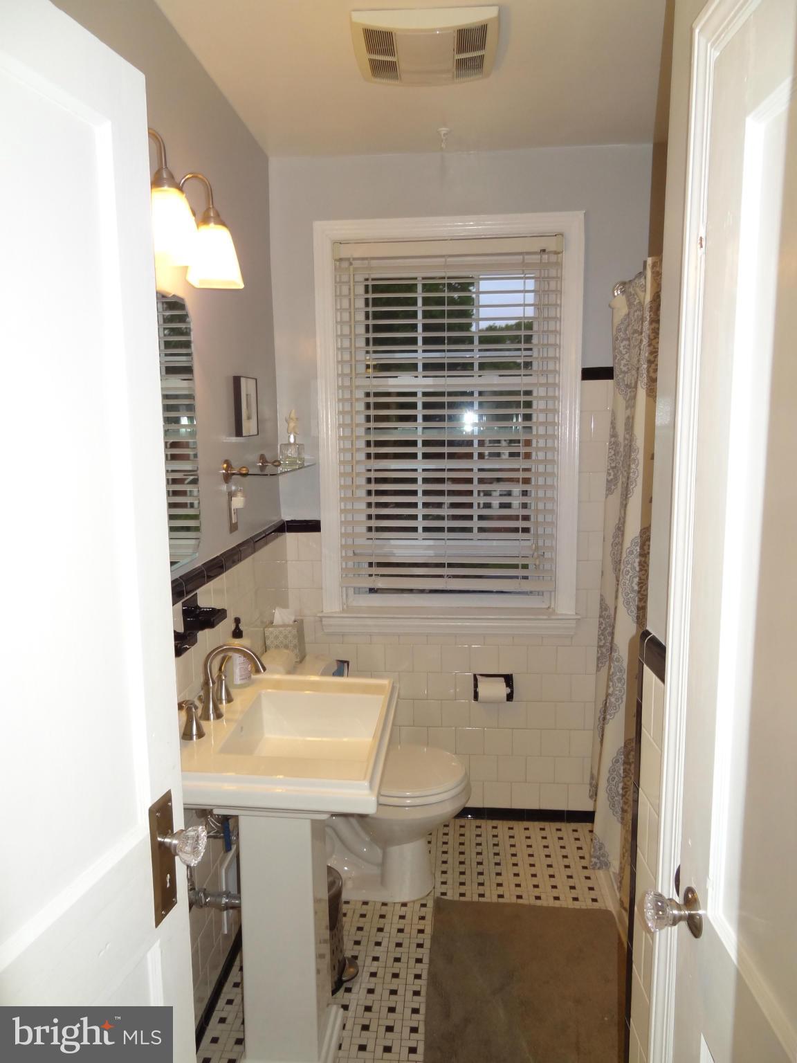 234 Blenheim Road Baltimore, MD 21212 - Photo 11 of 16 a bathroom with a sink a mirror and a shower