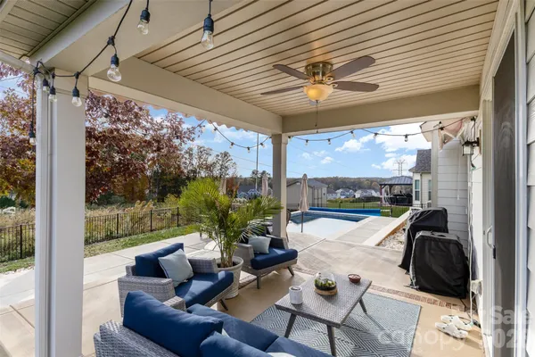a view of a patio with couches chairs and a floor to ceiling window