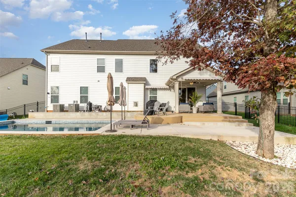 a view of a house with swimming pool and sitting area