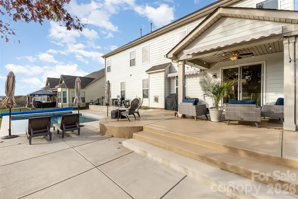 a view of a patio with couches table and chairs and potted plants