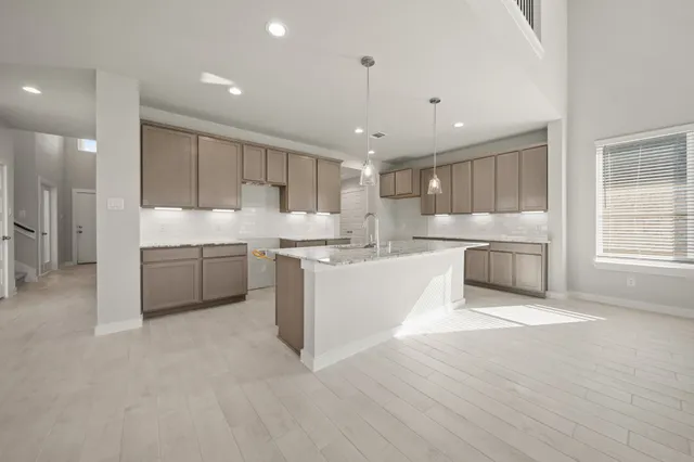 a large kitchen with kitchen island a sink stainless steel appliances and cabinets