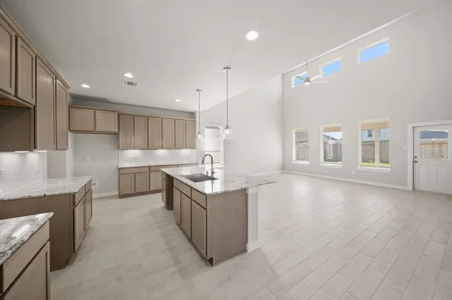 a kitchen with stainless steel appliances granite countertop a sink a stove and a refrigerator