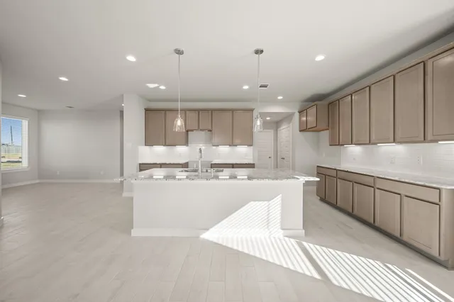 a kitchen with kitchen island granite countertop wooden cabinets and white stainless steel appliances